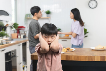 domestic violence. Stressed Asian kid covering his face after mom and dad started arguing.