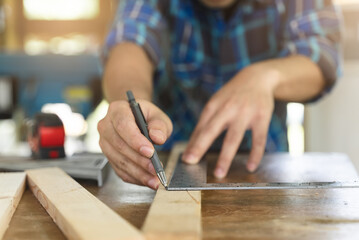 Hands of person doing diy project at home. Man measuring wood to doing cabinet craftworks as a...