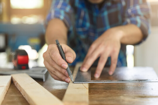 Hands of person doing diy project at home. Man measuring wood to doing cabinet craftworks as a hobby.