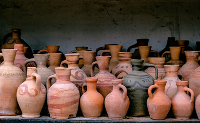 Ancient clay jars. Weathered, textured old jars on shelf.