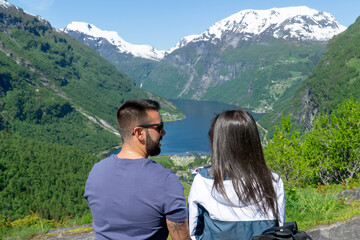 Fototapeta na wymiar Couple in love looking at each other with the Geirangerfjord in the background on a sunny day.
