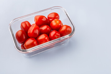 Glass box with fresh cherry tomatoes.  Vegetables in a glass containers. Food storage concept