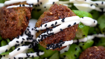 Vegan meatballs Falafel on the green salad with mayo and black cumin spice 