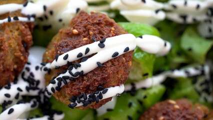 Vegan meatballs Falafel on the green salad with mayo and black cumin spice 