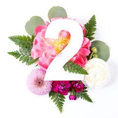 Creative layout with colorful flowers, leaves and number two isolated on white background....