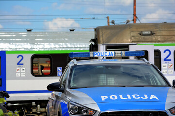 Radiowóz polskiej policji podczas obsługi interwencji na terenie kolejowym.  - obrazy, fototapety, plakaty