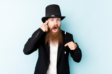 Fototapeta premium Young magician man isolated on blue background showing a disappointment gesture with forefinger.