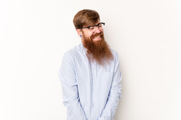 Young caucasian red-haired man isolated on white background laughs and closes eyes, feels relaxed and happy.