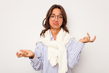 Young hispanic woman isolated on white background doubting and shrugging shoulders in questioning...
