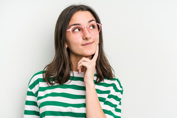 Young caucasian woman wearing a glasses isolated on blue background relaxed thinking about something looking at a copy space.