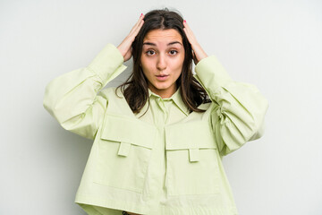 Young caucasian woman isolated on white background being shocked, she has remembered important meeting.