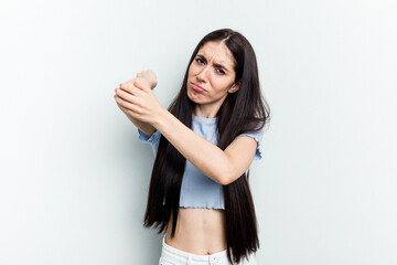 Young caucasian woman isolated on white background having a neck pain due to stress, massaging and touching it with hand.