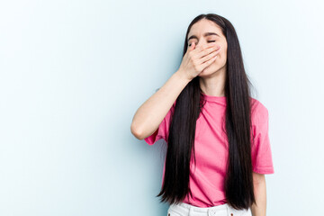 Young caucasian woman isolated on blue background laughing happy, carefree, natural emotion.