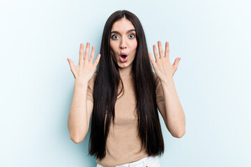 Young caucasian woman isolated on blue background showing number ten with hands.