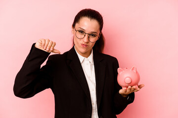 Young business caucasian woman holding piggybank isolated on pink background feels proud and self confident, example to follow.