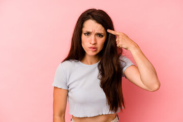 Young caucasian woman isolated on pink background showing a disappointment gesture with forefinger.