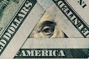 President Franklin's eye in a triangle of hundred dollar bills. Words visible on banknotes:...