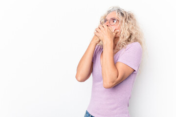 Middle age caucasian woman isolated on white background thoughtful looking to a copy space covering mouth with hand.