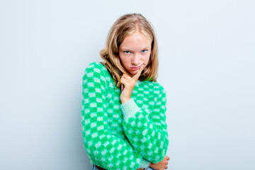 Caucasian teen girl isolated on blue background contemplating, planning a strategy, thinking about the way of a business.