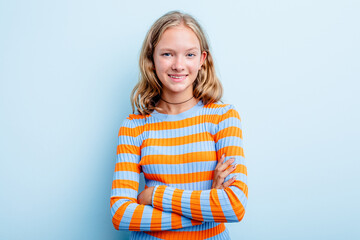 Caucasian teen girl isolated on blue background who feels confident, crossing arms with determination.