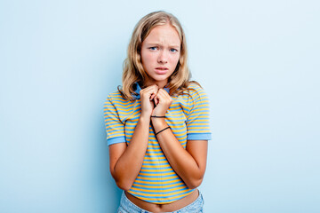 Caucasian teen girl isolated on blue background scared and afraid.