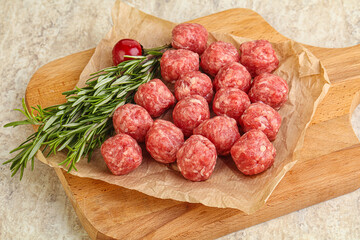 Raw uncooked beef meatballs served rosemary