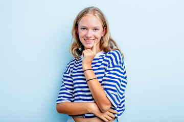 Caucasian teen girl isolated on blue background smiling happy and confident, touching chin with hand.