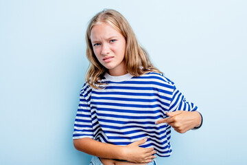 Caucasian teen girl isolated on blue background having a liver pain, stomach ache.