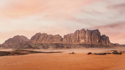 Rocky scenery in Wadi Rum desert during overcast morning, camp tents visible in distance © Lubo Ivanko