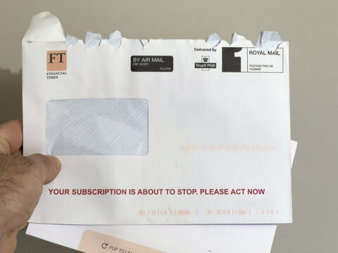 London, United Kingdom - Jan 3, 2022: POV male hand holding postal envelope with message your FT Financial Times subscription is about to stop. Please act now