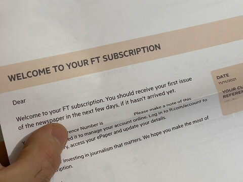London, United Kingdom - Jan 3, 2022: POV male hand holding postal envelope with message Welcome to your FT Financial Times subscription.