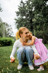 Happy harmonious family outdoors. Young mother and daughter spend joint activities on holidays.