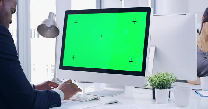 Businesspeople working on green screen computers with chroma key and writing notes while sitting in a modern office. Serious, diverse and busy man and woman typing on a desktop with tracking markers