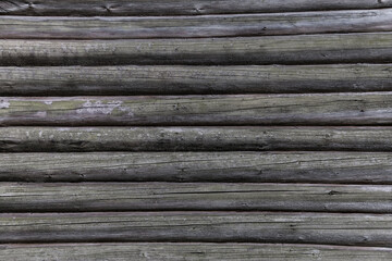 Texture of an old log wall. Close-up. The texture of old wood is used in design, furniture making and construction.
