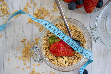 Oatmeal, strawberry, measuring tape on wooden background