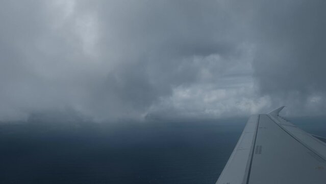 View From The Passenger Seat Window, Airplane Wing Passing Over The Clouds In A Cloudy Day In The Middle Of The Atlantic Ocean