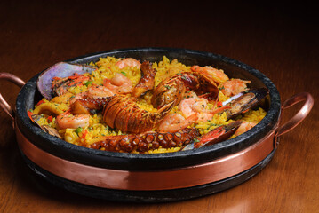 Traditional spanish paella with seafood on wooden table. Spanish cuisine.