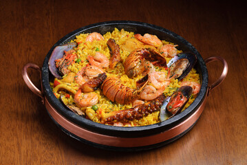 Traditional spanish paella with seafood on wooden table. Spanish cuisine.