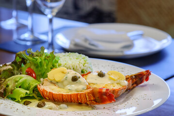 Lobster with rice and salad on a wooden table. Seafood table set.