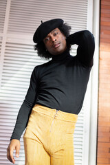 Portrait of African American young adult man dressed in 70's fashion. Provocative attitude.