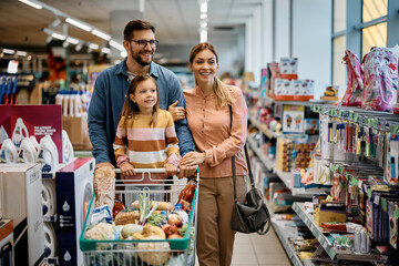 Happy family looking for school supplies in supermarket.