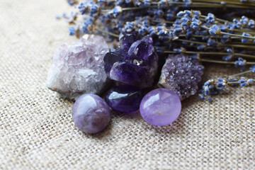 Beautiful amethyst stones and amethyst druze with a dry bouquet of lavender against a background of...