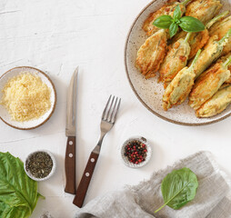 Fried zucchini flowers stuffed with cream cheese served on the plate, tasty Italian dish summer, top view
