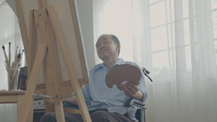 Artist concept of 4k Resolution. Asian man painting in the living room. Artist is creating work. Leisure activities and hobbies.