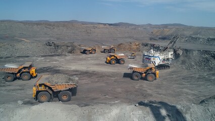 Group of 6 dump trucks on loading. Walking excavator in russian flag color in coal mine. © planarfilm