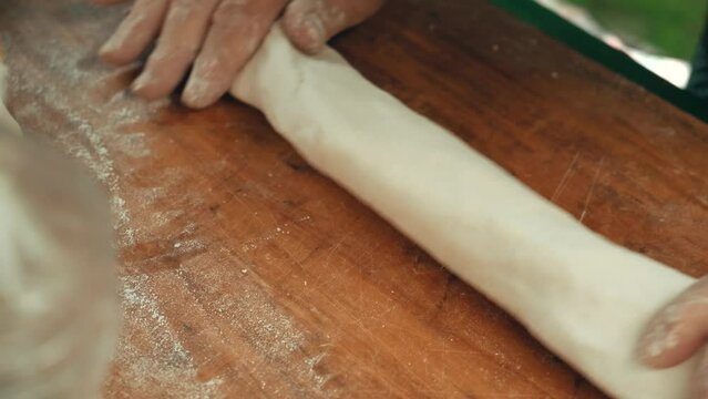 hands mold homemade dumplings from dough. grandma cooks homemade food