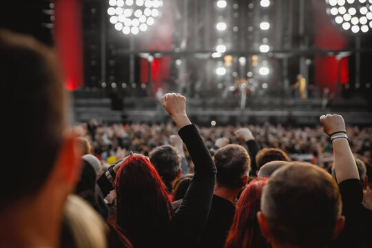 The crowd at a concert. People with raised hands on the dance floor.