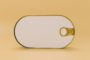 Closed golden rounded empty sardine fish tin can with an empty white paper mockup on a yellow...