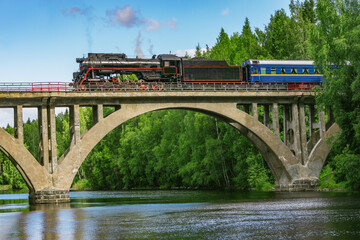 Retro steam train moves above the river.