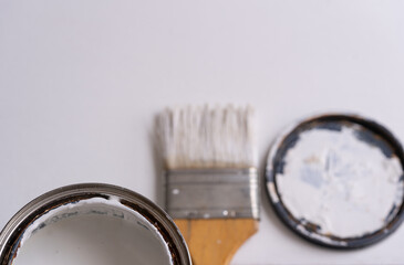 brocha con bote de pintura blanca y fondo blanco